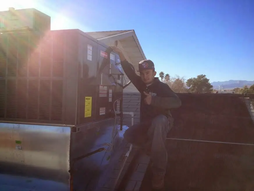 HVAC technician performing Boiler Repair on a rooftop unit in Plumsted